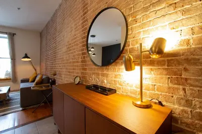 a mirror on a brick wall in a living room at VINTAGE - SelfCheckIn - Rooftop - Terraces - St-Denis in Montréal