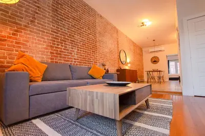 a living room with a couch and a brick wall at VINTAGE - SelfCheckIn - Rooftop - Terraces - St-Denis in Montréal