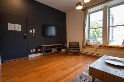 a living room with a black wall and a tv at VINTAGE - SelfCheckIn - Rooftop - Terraces - St-Denis in Montréal