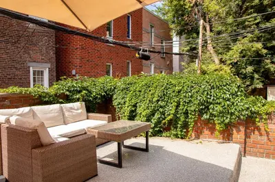 a patio with a couch and a table and a brick wall at VINTAGE - SelfCheckIn - Rooftop - Terraces - St-Denis in Montréal