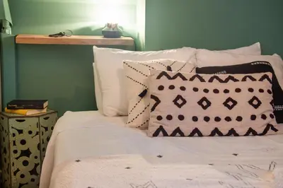 a bed with white pillows and a green wall at BOHEMIAN - SelfCheckIn - Rooftop - Terraces - St-Denis in Montréal