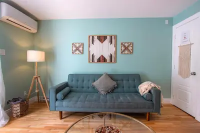 a living room with a blue couch and a glass table at BOHEMIAN - SelfCheckIn - Rooftop - Terraces - St-Denis in Montréal