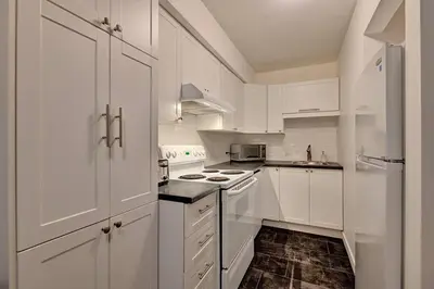 a white kitchen with white cabinets and white appliances at *Nouveauté* Foyer au bois, Plage, Montagne et + in Magog-Orford
