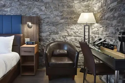 a bedroom with a bed and a desk and a chair at Hotel Épik Montréal in Montréal