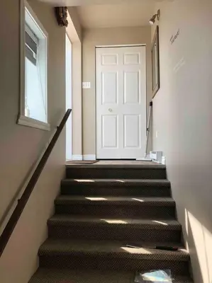a stairway with a white door and a white stair at Spacieux 4,5 Parfait pour des Vacances Confortables ! in Lac-Mégantic