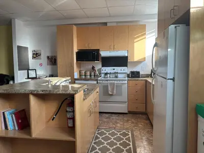a kitchen with white appliances and wooden cabinets at Spacieux 4,5 Parfait pour des Vacances Confortables ! in Lac-Mégantic