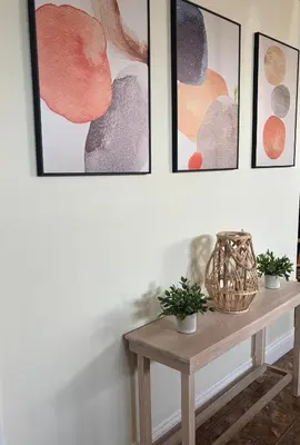 a table in a room with four pictures on the wall at Spacieux 4,5 Parfait pour des Vacances Confortables ! in Lac-Mégantic
