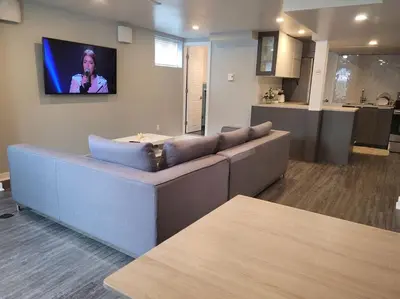 a living room with a couch and a tv on the wall at QUIET Appartment near Montreal CITQ 3O9764 in Longueuil