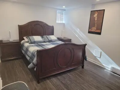 a bedroom with a large wooden bed with two pillows at QUIET Appartment near Montreal CITQ 3O9764 in Longueuil
