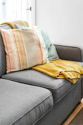a couch with three pillows on top of it at Le Karina - Vieux-Terrebonne in Terrebonne