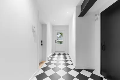 a hallway with a black and white checkered floor at Le Karina - Vieux-Terrebonne in Terrebonne