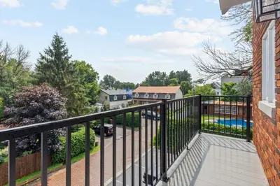 a balcony with a black railing and a yard at Le Karina - Vieux-Terrebonne in Terrebonne