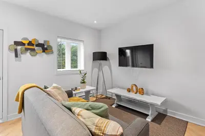 a living room with a couch and a tv at Le Karina - Vieux-Terrebonne in Terrebonne