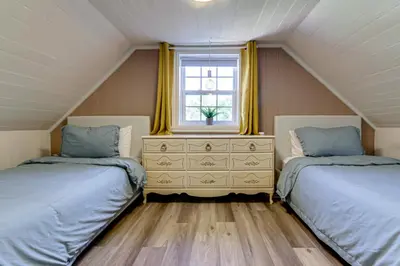 a attic bedroom with two beds and a dresser at Le Havre du Canal in Leclercville