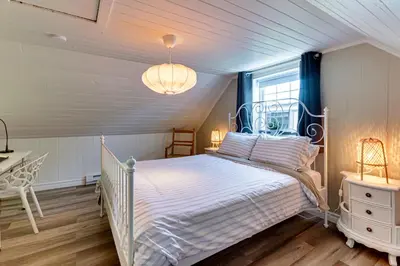 a bedroom with a white bed and a window at Le Havre du Canal in Leclercville