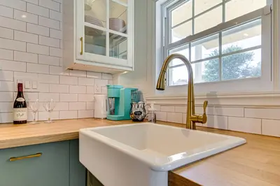 a white kitchen with a sink and a window at Le Havre du Canal in Leclercville