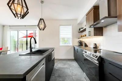 a kitchen with a sink and a counter at Le Memph Aigle spacious comfortable condo cottage eco friendly 3 bedrooms - hot tub & pool Memphrémagog Lake in Magog-Orford