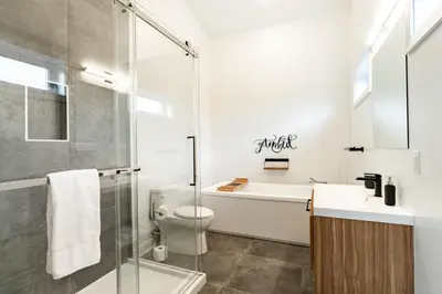 a bathroom with a shower toilet and a sink at Le Memph Aigle spacious comfortable condo cottage eco friendly 3 bedrooms - hot tub & pool Memphrémagog Lake in Magog-Orford