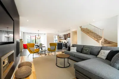 a living room with a couch and a table at Le Memph Aigle spacious comfortable condo cottage eco friendly 3 bedrooms - hot tub & pool Memphrémagog Lake in Magog-Orford
