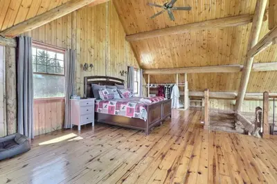 a bedroom with a bed and a wooden ceiling at Chalet en bois rond in Saint-Herménégilde
