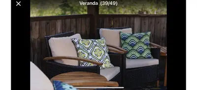two wicker chairs with pillows on a porch at Chalet en bois rond in Saint-Herménégilde