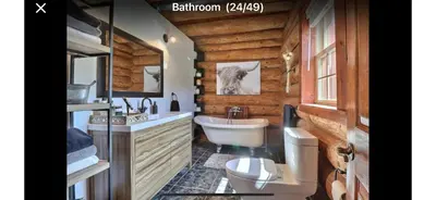 a bathroom with a toilet and a sink and a toilet istg at Chalet en bois rond in Saint-Herménégilde