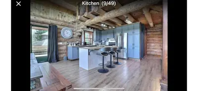 a kitchen with a counter and a clock on the wall at Chalet en bois rond in Saint-Herménégilde
