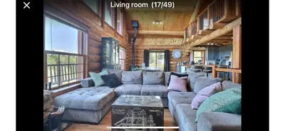 a living room with a couch and a table at Chalet en bois rond in Saint-Herménégilde
