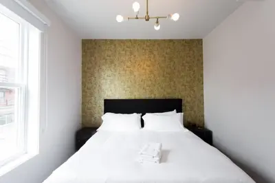 a bedroom with a large white bed with a window at Fresh 1 Bdr in the Heart of Mile End by Denstays in Montréal