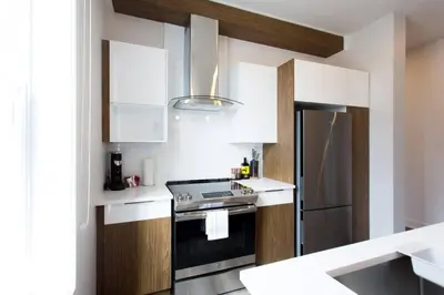 a kitchen with a stove and a refrigerator at Fresh 1 Bdr in the Heart of Mile End by Denstays in Montréal