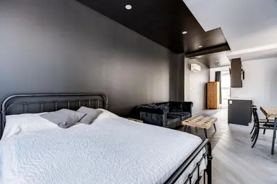 a bedroom with a large bed and a black wall at Le Black & White - Vieux-Terrebonne in Terrebonne