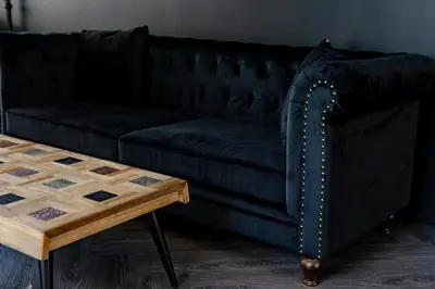 a black couch in a living room with a wooden table at Le Black & White - Vieux-Terrebonne in Terrebonne