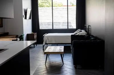 a living room with a bed and a couch and a table at Le Black & White - Vieux-Terrebonne in Terrebonne
