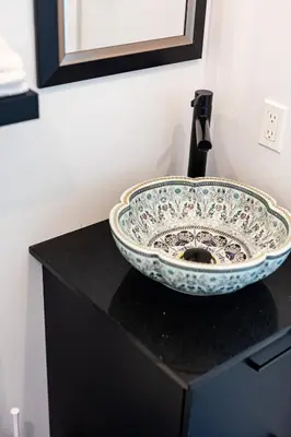 a bathroom sink sitting on a black counter top at Le Virtuose - Vieux-Terrebonne in Terrebonne
