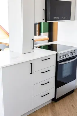 a white kitchen with a stove and a microwave at Le Virtuose - Vieux-Terrebonne in Terrebonne