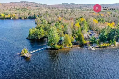 an island in the middle of a body of water at Aux Berges du Pont Suspendu / Grand Lac Brompton in Saint Denis de Brompton