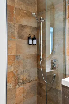 a bathroom with a shower with two bottles on the wall at The Nomad Saint Jacques in Montréal