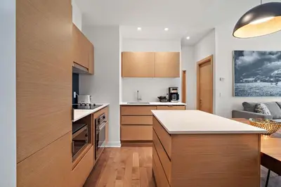 a kitchen with wooden cabinets and a kitchen island at The Nomad Saint Jacques in Montréal