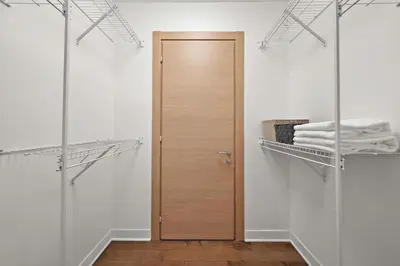 a closet with a wooden door and towels at The Nomad Saint Jacques in Montréal