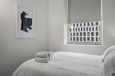 a white bedroom with a bed and a window at The Nomad Saint Jacques in Montréal