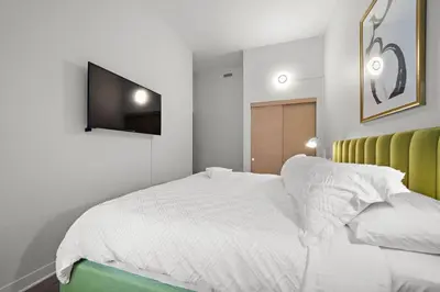 a bedroom with a bed with a tv on the wall at The Nomad Saint Jacques in Montréal