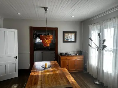 a dining room with a wooden table and a window at House & loft, pool table, ping-pong, fireplace, AC in Ayer's Cliff