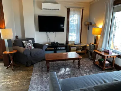 a living room with a couch and a tv at House & loft, pool table, ping-pong, fireplace, AC in Ayer's Cliff