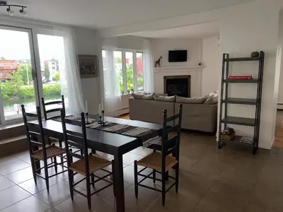 a living room with a table and chairs and a couch at Auberge des Cantons in Magog-Orford