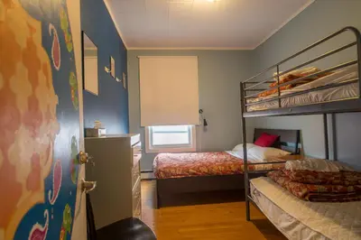 a bedroom with two bunk beds and a window at Auberge du Monde in Trois-Rivières