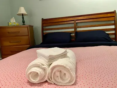 a bed with a pile of towels on it at Auberge du Monde in Trois-Rivières