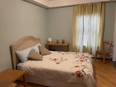a bedroom with a bed with a floral bedspread at Auberge du Monde in Trois-Rivières