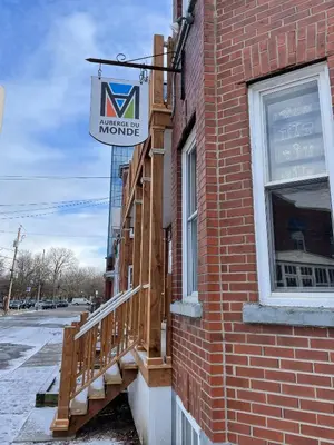 a building with a sign for a muncie mumble at Auberge du Monde in Trois-Rivières