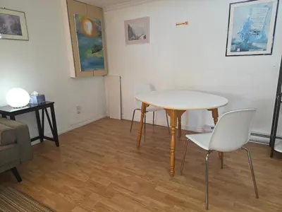 a table and chairs in a living room with a table and chairs at L ' Arlequin Suite et logement in Vaudreuil-Dorion