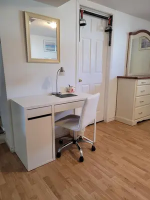 a white desk with a chair and a sink at L ' Arlequin Suite et logement in Vaudreuil-Dorion